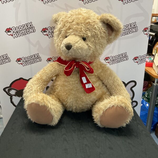 Large teddy bear with a red bow, classic plush toy.