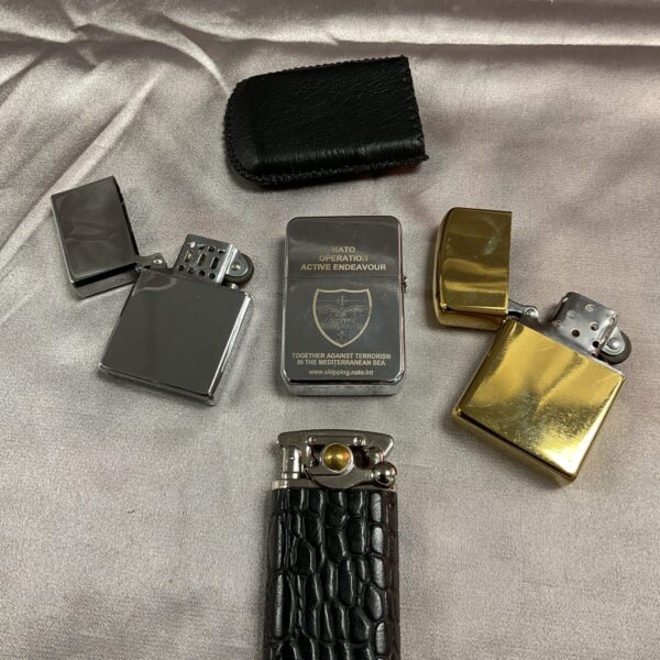 Lot of four vintage cigarette lighters in a collectible display.