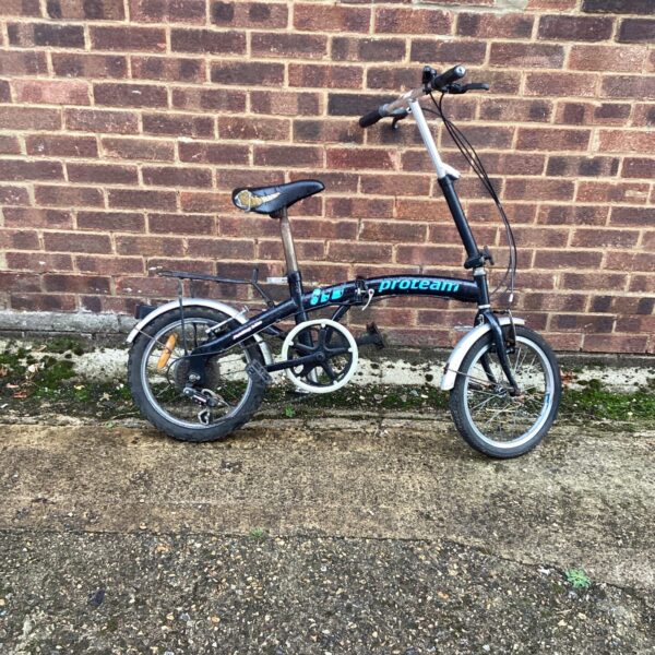 Vintage Proteam folding bike in a folded position.