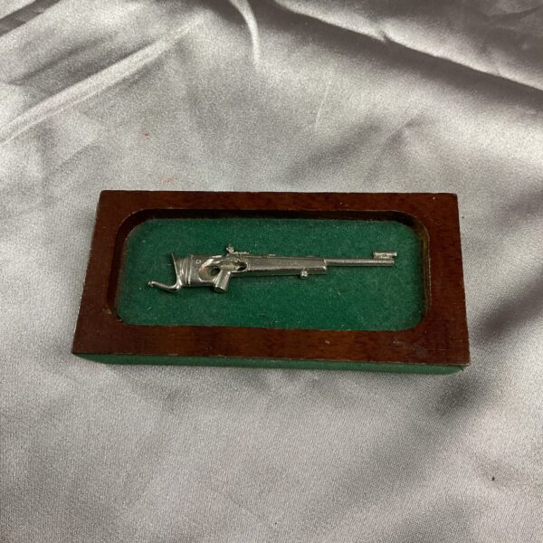 Vintage shooting trophy with miniature rifle on wooden base.