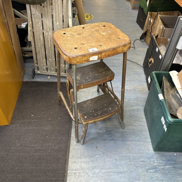 Vintage metal step stool with three steps, showing signs of age.