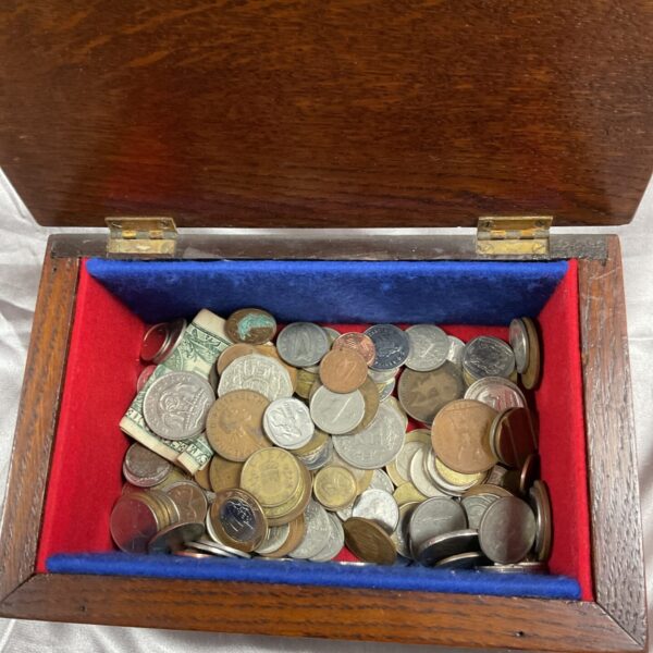 Assorted coin lot and banknotes inside a wooden box.