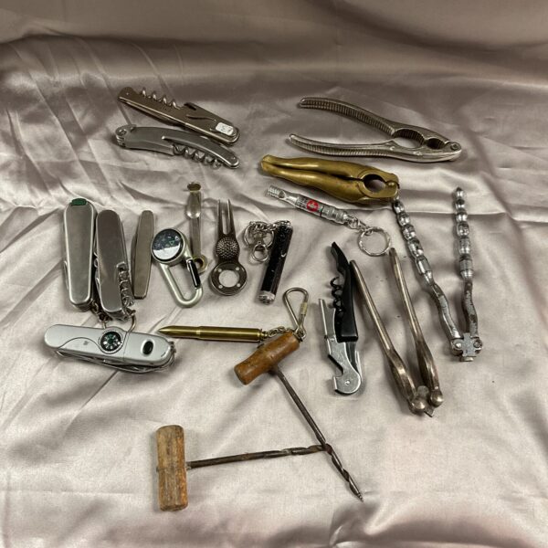 Vintage collection of penknives, corkscrews, and nutcrackers on display.