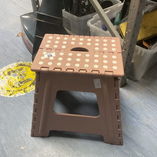Pink folding gardening stool for outdoor use.