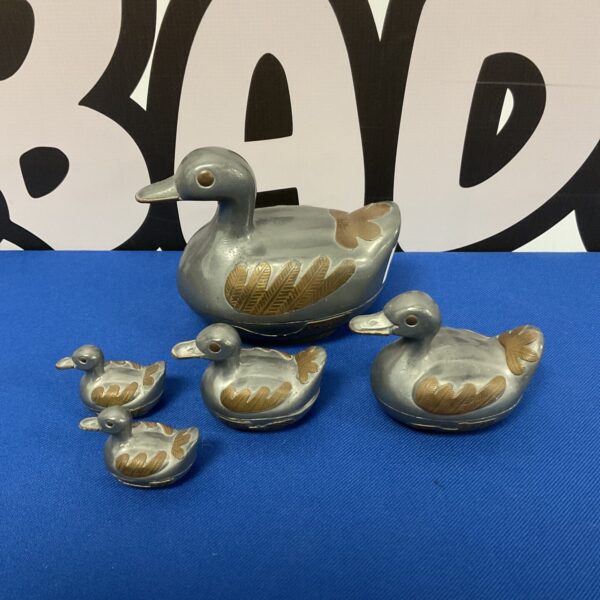 Vintage pewter duck family trinket pots on display.
