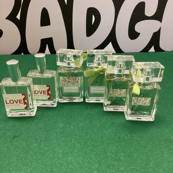 Six Next perfume bottles, including L’Essence and Love fragrances.