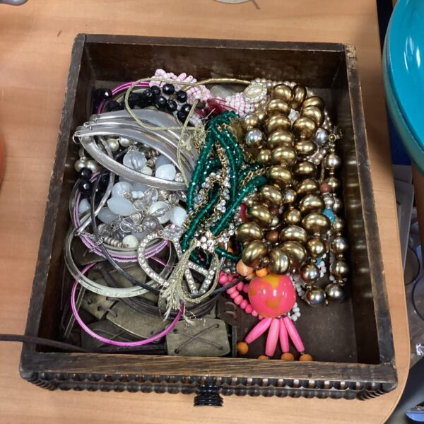 Colourful tray of vintage and modern costume jewellery assortment.