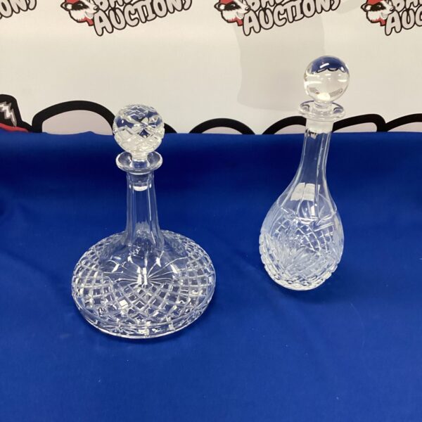 Two elegant crystal decanters with intricate cut glass designs.