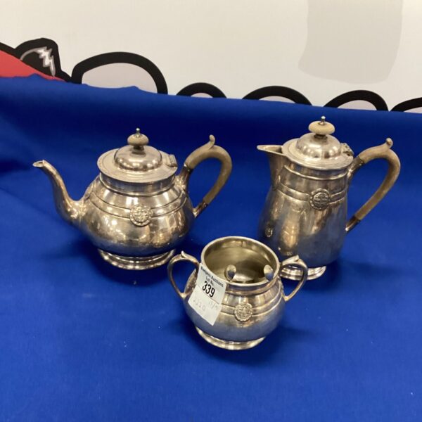 Vintage silverplate tea set with teapot, cream jug, and sugar bowl.