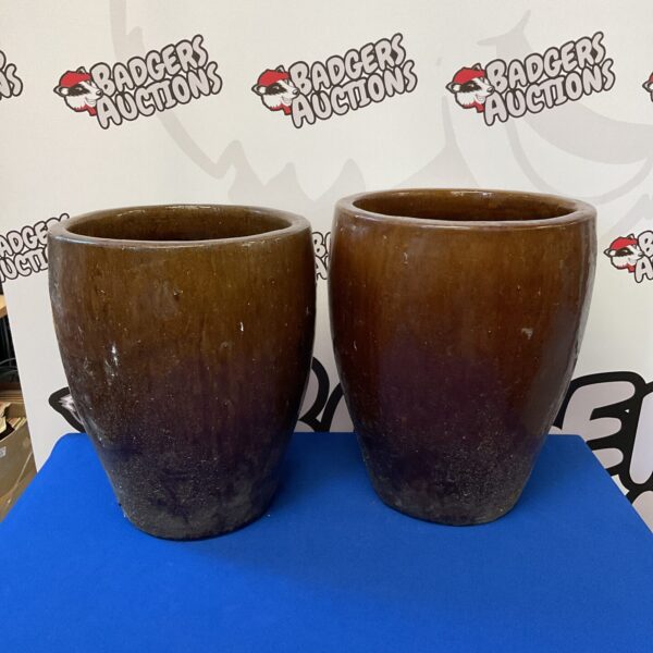 Pair of large brown glazed pottery plant pots for garden display.