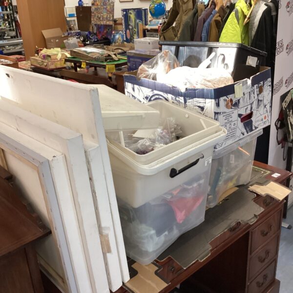 Overview of a large craft supply lot with canvases and storage containers.