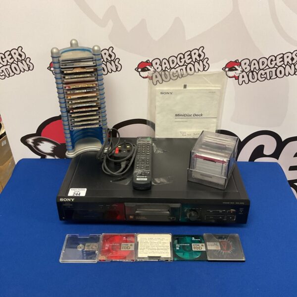 Silver Sony MDS-JE330 minidisc deck with remote and minidiscs.