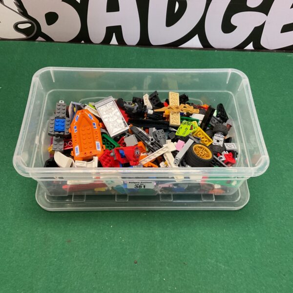 Colourful mixed Lego bricks in a plastic storage box.