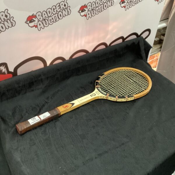 Vintage Spalding tennis racquet with wooden frame and classic design.