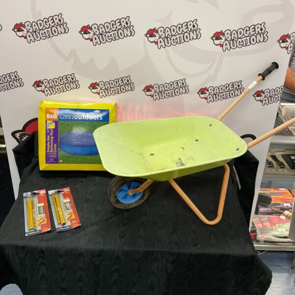 Red kids wheelbarrow with B&Q pool cover and stationery.