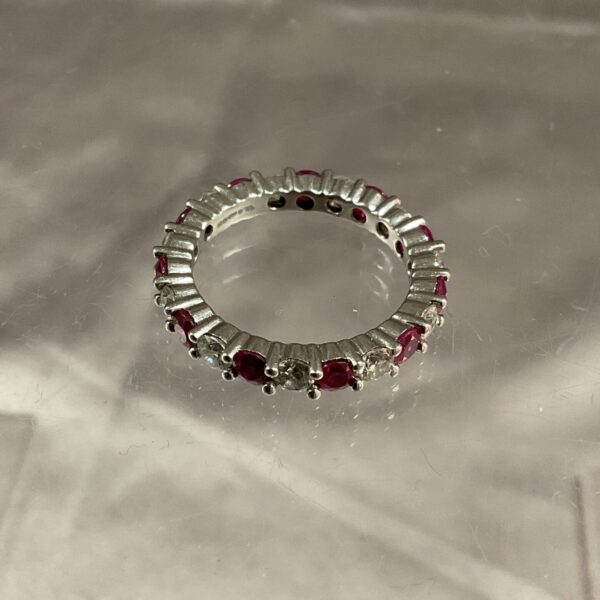 Platinum ring with alternating rubies and diamonds.