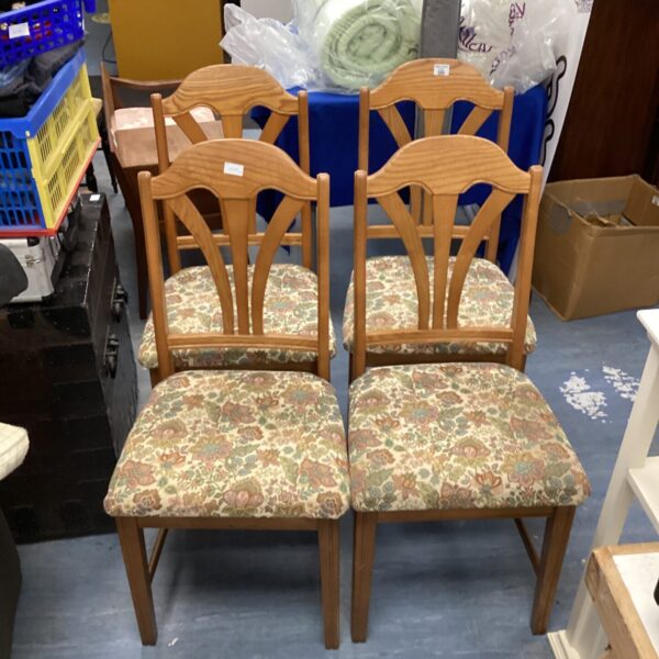 Four vintage Jentique dining chairs with floral upholstery.