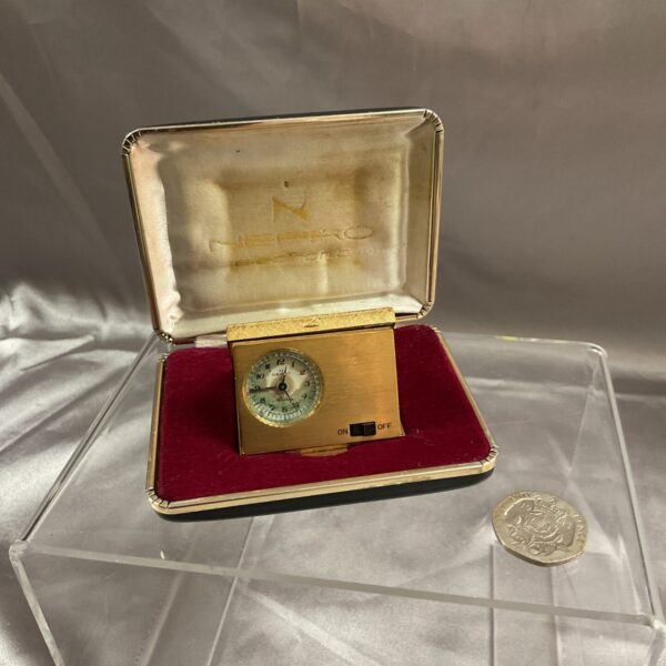 Gold vintage Nepro electronic alarm clock on display.