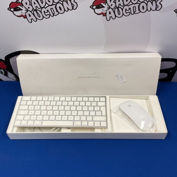 Apple wireless keyboard and mouse set on a white surface.