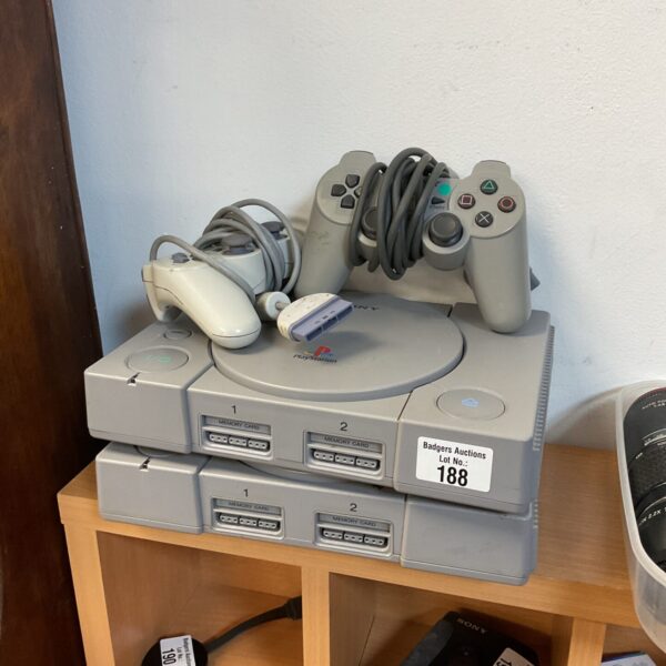 Two Sony PlayStation consoles with controllers, retro gaming system.