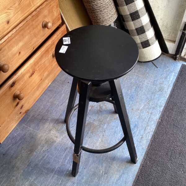 Vintage wooden swivel stool with a circular seat and splayed legs.