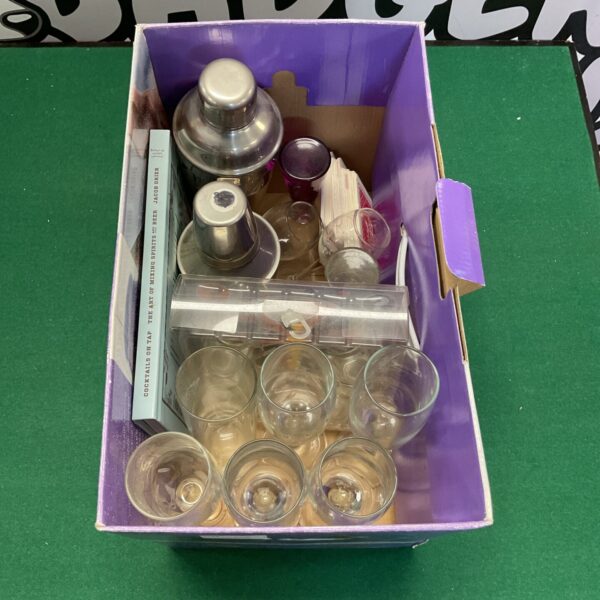 Collection of vintage cocktail glasses and shakers for home bar.