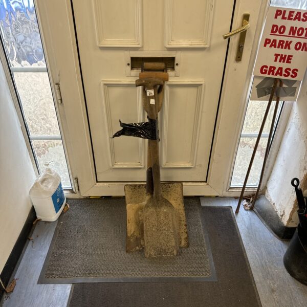 Vintage garden shovel with a worn steel blade and wooden handle.