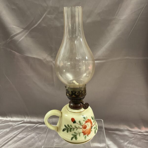 Vintage ceramic oil lamp with hand-painted floral design.
