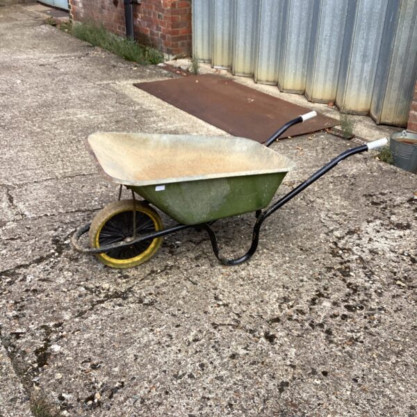 Vintage Chillington wheelbarrow in a garden setting.