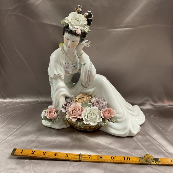 Vintage porcelain Geisha figurine with flower basket.