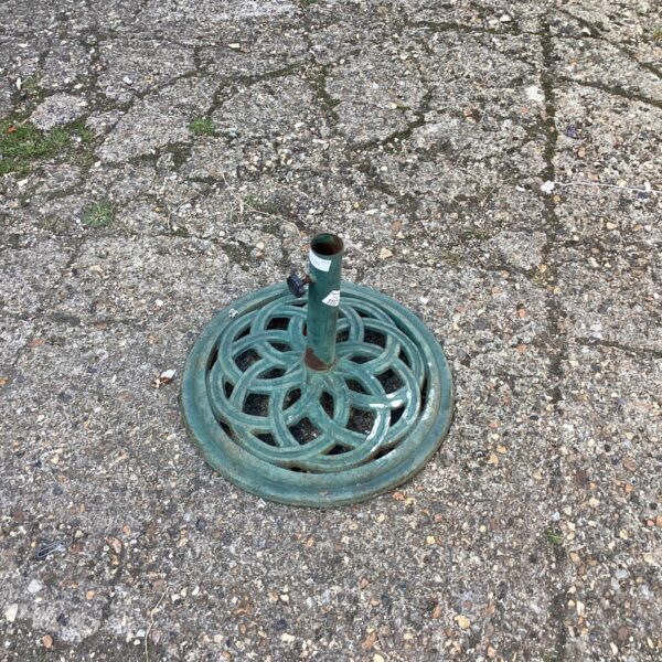 Decorative metal parasol base for garden or patio use.