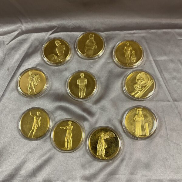 Set of ten gold plated Greek god coins on grey background.
