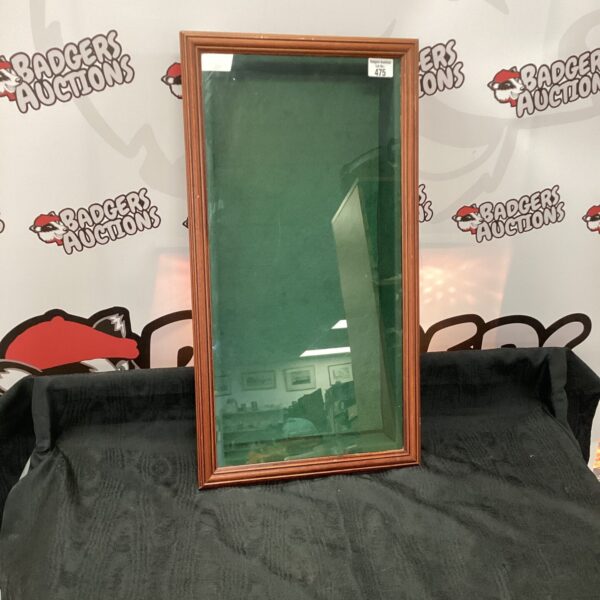 Antique green velvet glass cabinet for displaying collectibles.