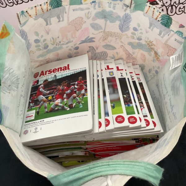 Vintage Arsenal football programmes in a bag, collectable memorabilia.