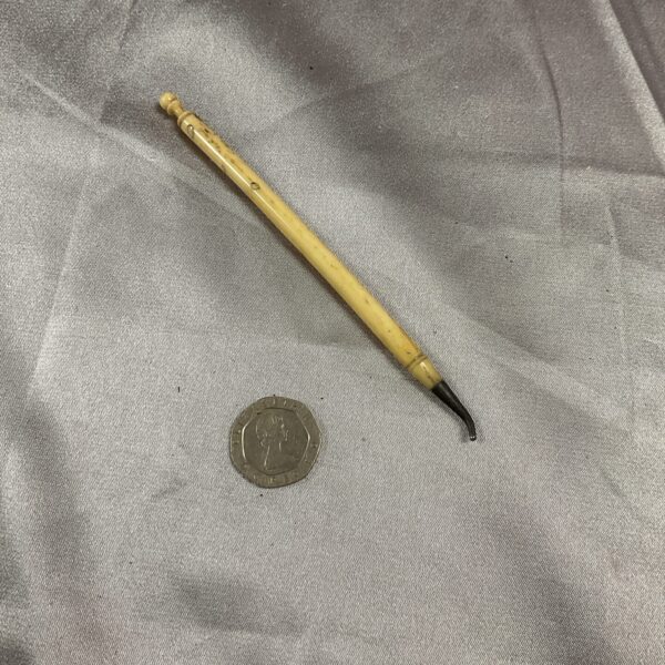 Antique bone pencil with a pointed tip, vintage writing tool.
