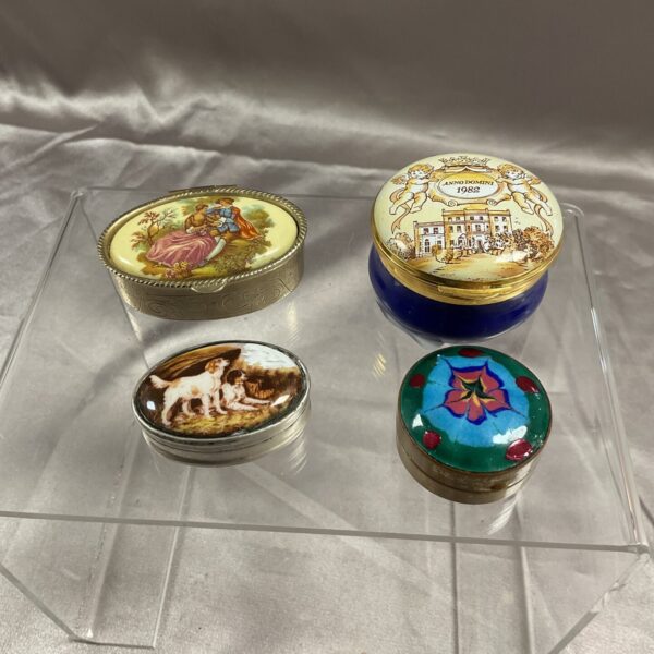 Antique enamel trinket pot with floral design and silver rim.