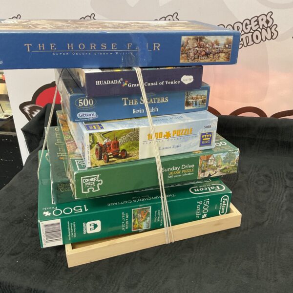Bundle of vintage jigsaw puzzles by Falcon and Humada, featuring artwork.