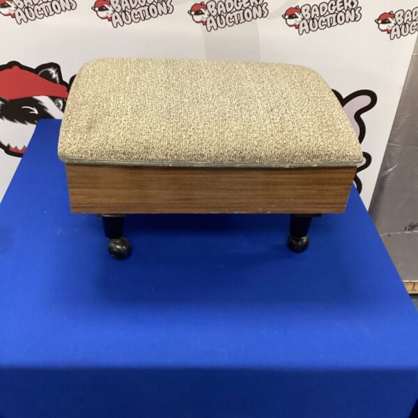 Vintage sewing box with supplies on a blue table.