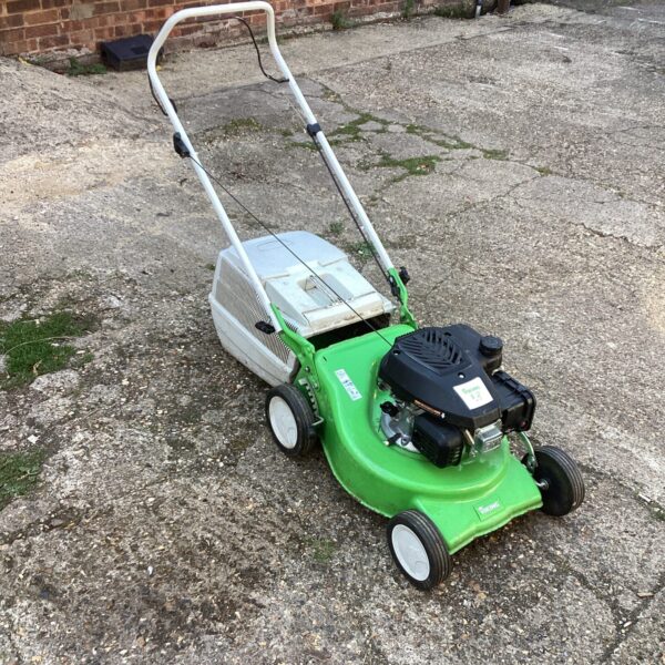 Side view of a vintage Viking rotary lawn mower in a garden.