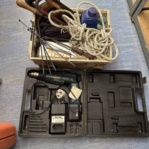 Mixed tool lot in wooden box with electric drill and crowbar.