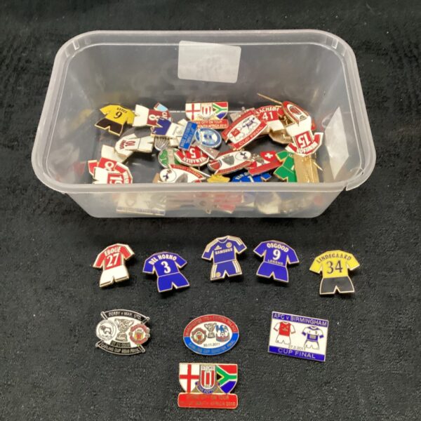 Assorted football club pin badges, collectible enamel badges on display.