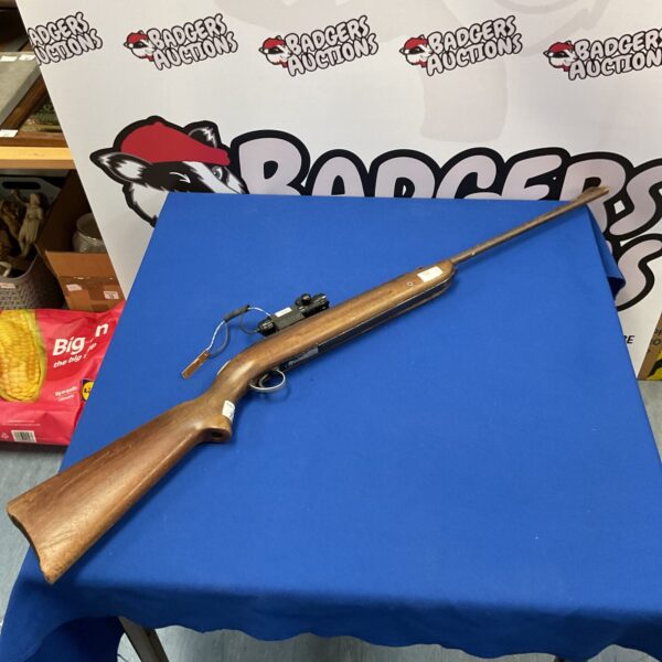 Vintage air rifle with laser dot sight for restoration.
