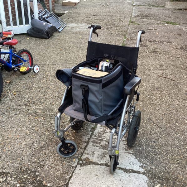 Side view of a Karma electric wheelchair with a basket.