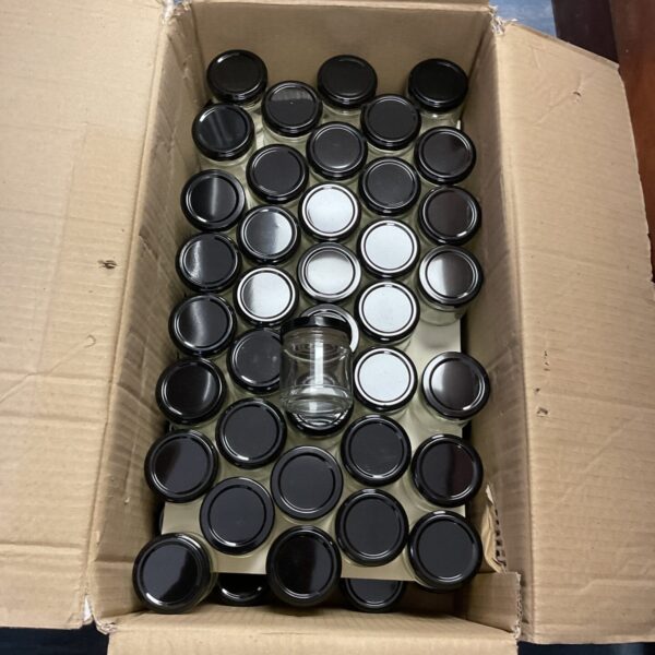 Lot of reusable glass preserve jars for canning and storage.