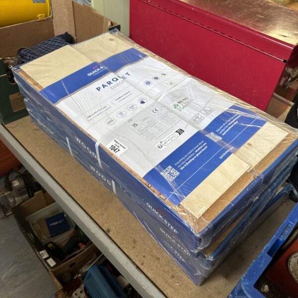 Three unopened packs of Quickstep Parquet flooring for home renovation.