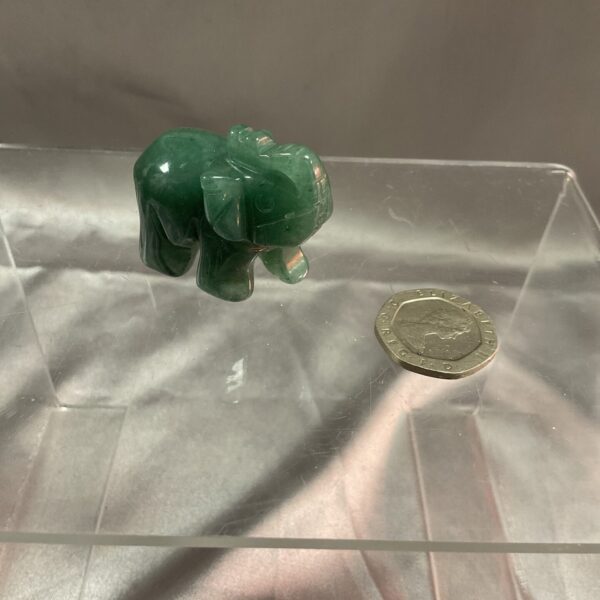 Small green jade elephant figurine, detailed carving.