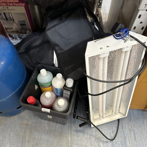 Grow tent setup with plant nutrients and chemicals for indoor gardening.
