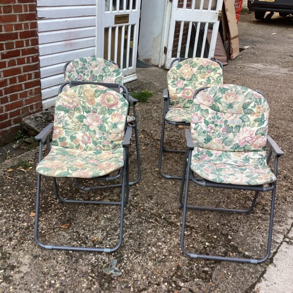 Set of four vintage floral folding garden chairs for outdoor use.