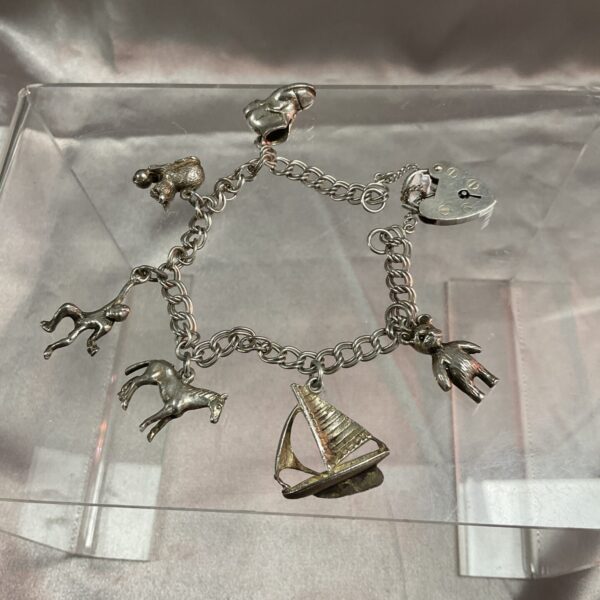 Vintage silver charm bracelet with detailed charms.