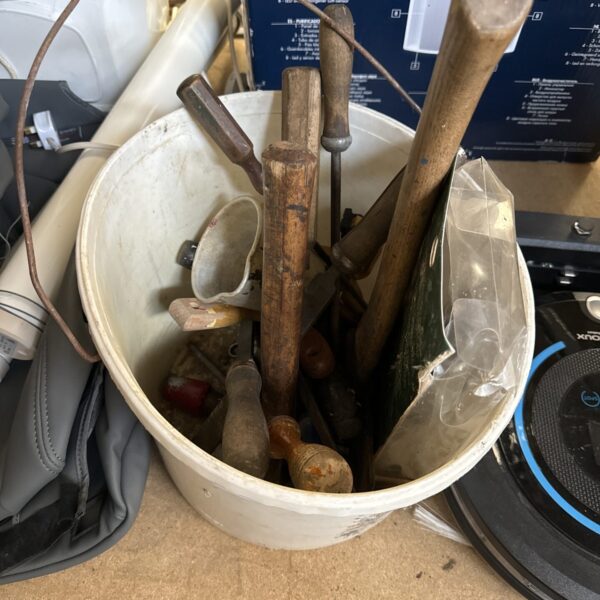 Rusty vintage hand tools in a metal bucket.